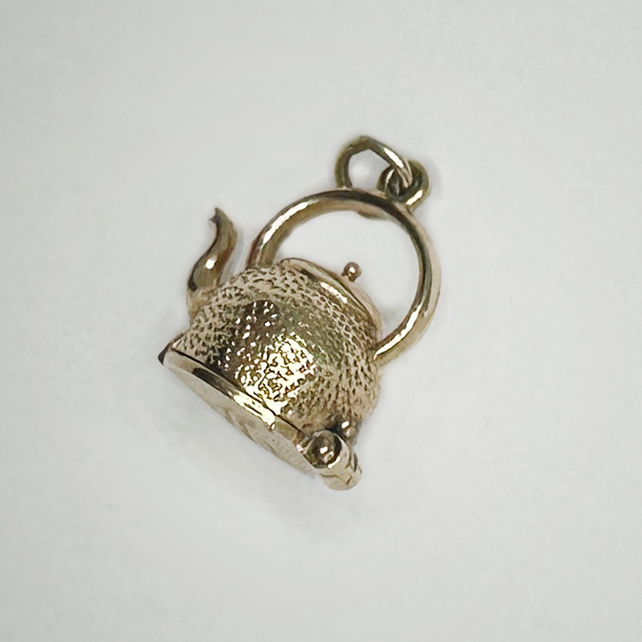 Kettle of Fish Gold Charm, textured dinky handled kettle which opens on a hinge on the bottom of the kettle to reveal fish. Hence the saying 'Kettle of Fish'. The charm has a full hallmark on the bottom Birmingham 1997. The hinge is in good working condition and intact. 
