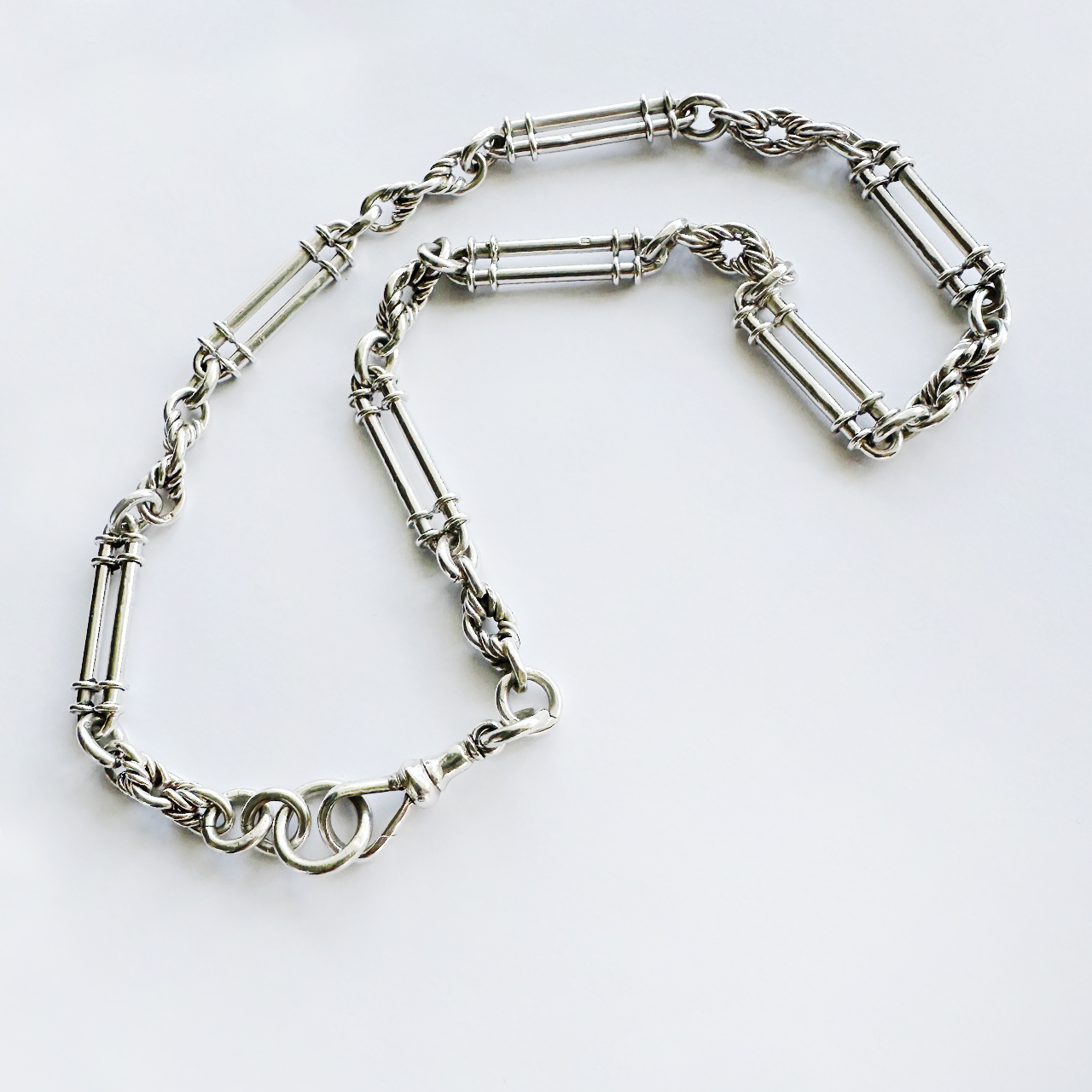Unique Fancy Silver Albert Antique Trombone Chain. The trombone links are 3cm long, each hallmarked with the the sterling lion and the securing dog clip has the hallmark for Birmingham 1907. Each trombone link has fetter link spacers and the total length of the chain is 18 inches. A beautiful Edwardian trombone link Albert chain.